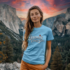 A woman wearing a light blue shirt that says "Yosemite Valley Girl" against Yosemite National Park in the background